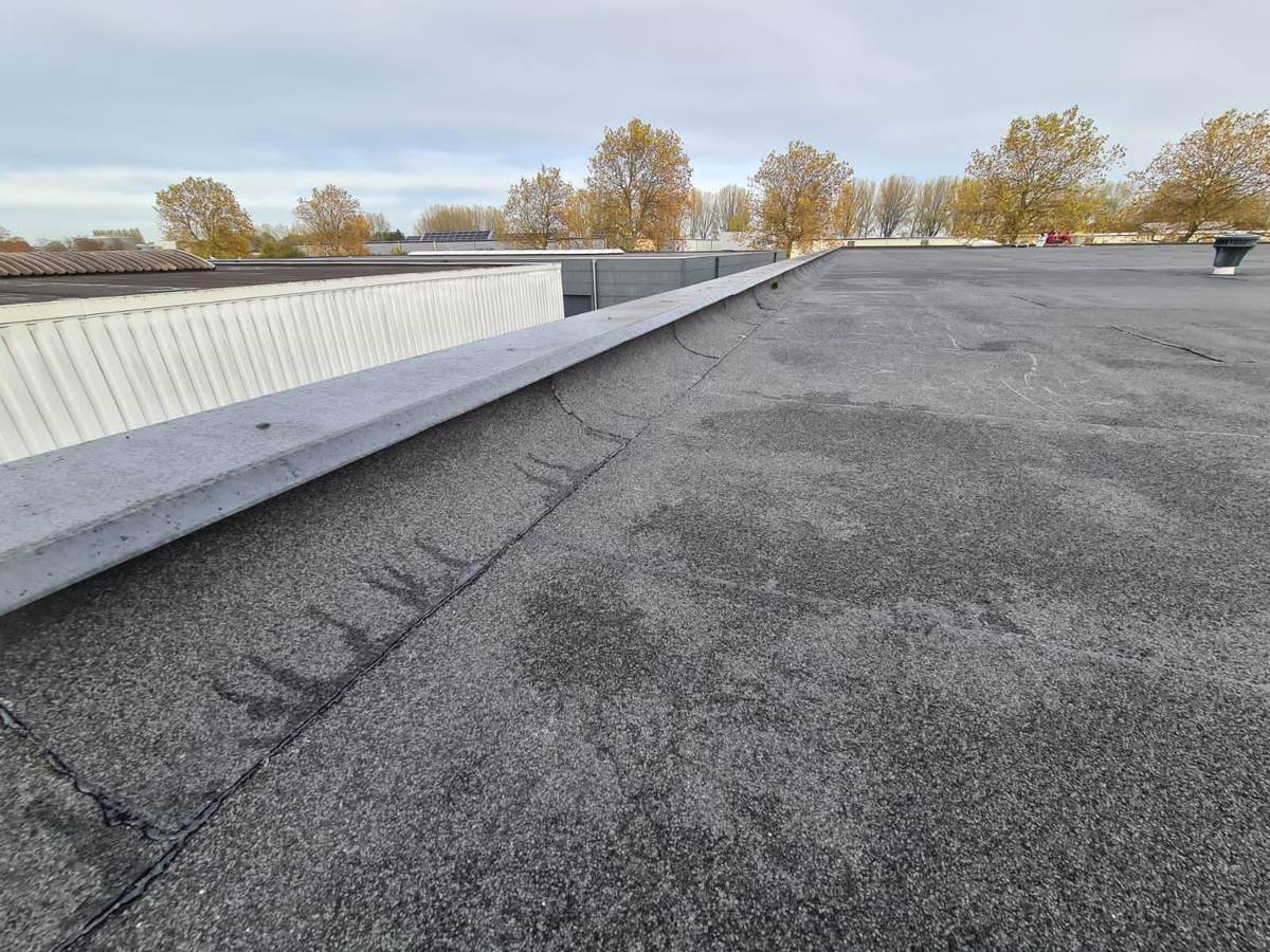 Nieuwe bitumen langs de dakrand van een bedrijfspand in Dronten